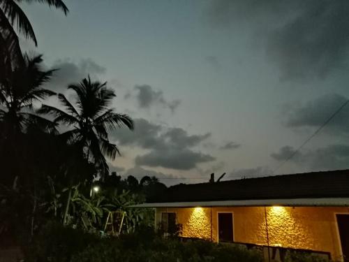 a house with lights on the side of it at night at jasmine land homestay in Udupi