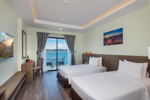 a hotel room with two beds and a view of the ocean at Xavia Hotel in Nha Trang