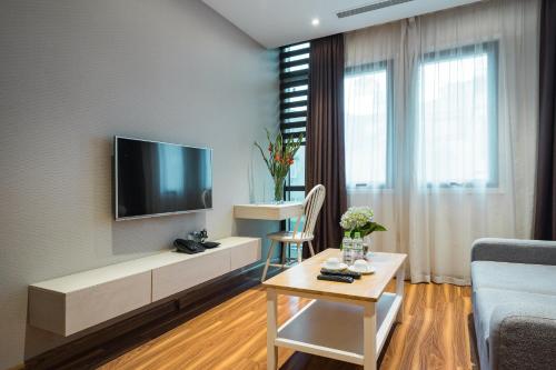a living room with a television on a wall at HNC Premier Hotel & Residences in Hanoi