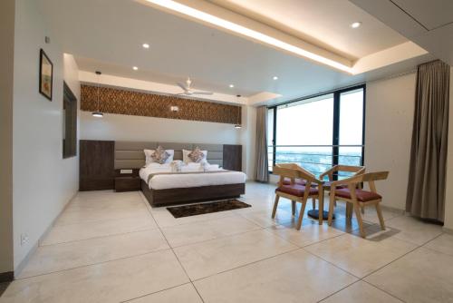 a bedroom with a bed and a table and chairs at HOTEL SILVERA GRAND in Ahmedabad