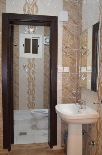 a bathroom with a toilet and a sink at شقق برج الشمال للشقق المخدومة Burj Alshmmal serviced apartments in Tabuk