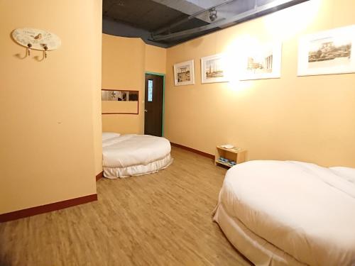 a hotel room with two beds in a room at DongNing Atlas Hotel in Tainan