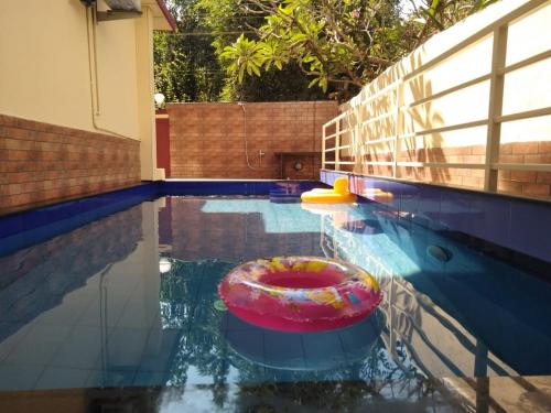 une piscine avec un anneau rouge dans l'eau dans l'établissement di CASA Resort, à Calangute