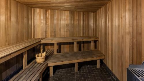 a sauna with a bench and a bucket in it at Oaks Brisbane Aurora Suites in Brisbane