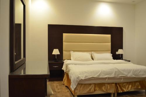 a bedroom with a large bed with a large headboard at شقق برج الشمال للشقق المخدومة Burj Alshmmal serviced apartments in Tabuk