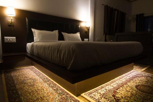 a bedroom with a large bed with white sheets and a rug at Samskara & Samsara in Lansdowne