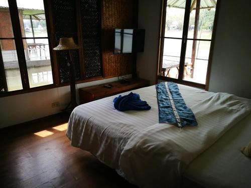 um quarto com uma cama com um roupão azul em River Marina Resort em Uthai Thani