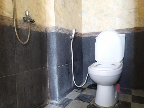 La salle de bains est pourvue d'une douche et de toilettes. dans l'établissement OYO 2991 Satya Homestay, à Makassar