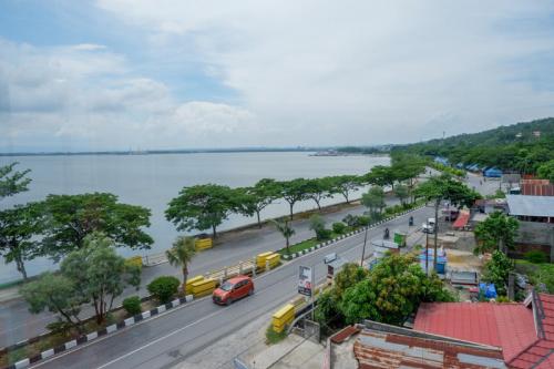a view of a street with cars on a road next to the water at RedDoorz near Kendari Beach 2 in Kendari