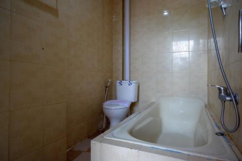 a bathroom with a bath tub and a toilet at RedDoorz near Kendari Beach 2 in Kendari