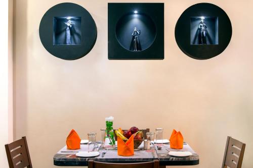 a table with four pictures on the wall at Lords Eco Inn Morbi in Morbi