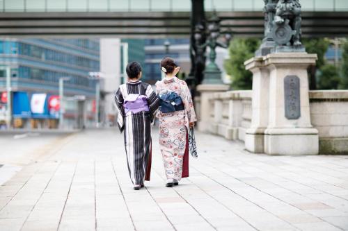 two people standing next to each other on a sidewalk at Mandarin Oriental Tokyo in Tokyo