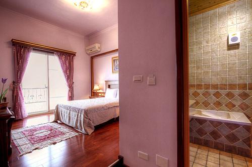 a bedroom with a bed and a bathroom with a tub at Aurora in Wujie
