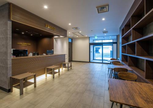 a restaurant with wooden tables and chairs and a counter at Hotel Trend Numazu Ekimae in Numazu