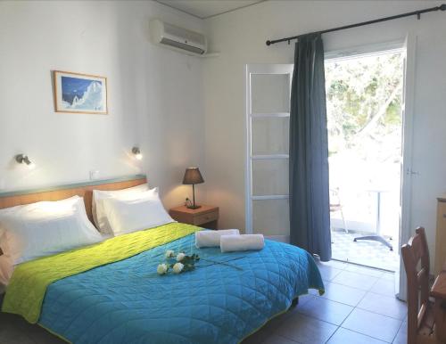 a bedroom with a bed with a blue and yellow blanket at Lefkothea Hotel in Kamari