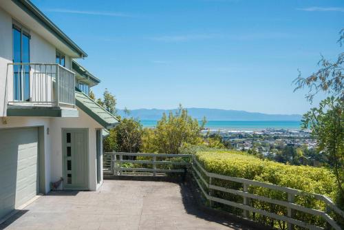 a house with a balcony and a driveway at Hilltop Getaway in Nelson