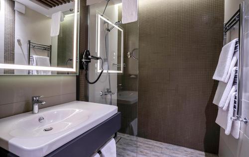 a white bathroom with a sink and a shower at Hotel Kaleli in Gaziantep