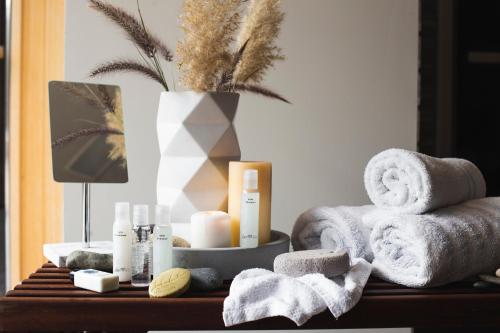 a bathroom table with towels and a vase with a plant at Leonardo Plaza Netanya Hotel in Netanya