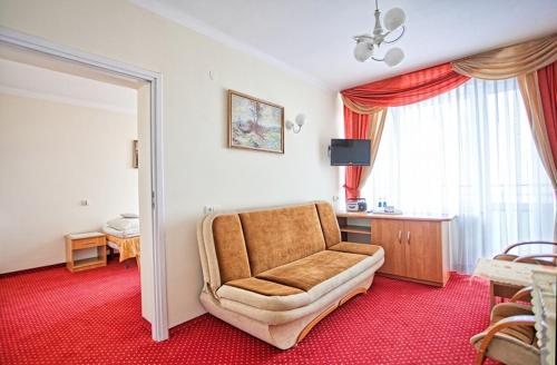 a living room with a couch and a table and a window at Ośrodek Uzdrowiskowy Biawena in Wysowa-Zdrój