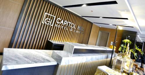 a lobby of a restaurant with a counter and a sign at Capitol Hill Hotel and Suites in Angeles