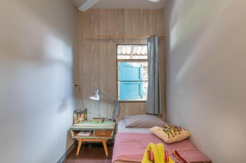 Un dormitorio pequeño con una cama y una ventana. en Sor Vorapin Muay Thai Home, en Bangkok