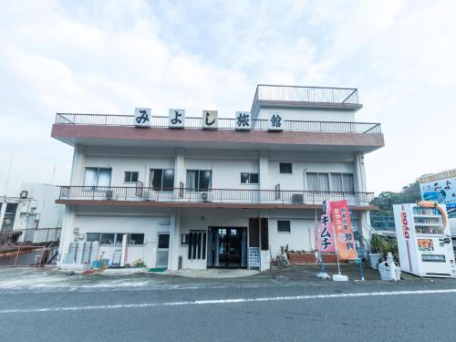 a white building with writing on the top of it at Tabist Miyoshi Ryokan Odawara Manazuru in Odawara