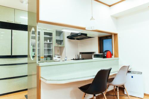 uma cozinha com duas cadeiras e um balcão em まるまる貸切,羽田空港から一番近いyu`s house em Tóquio