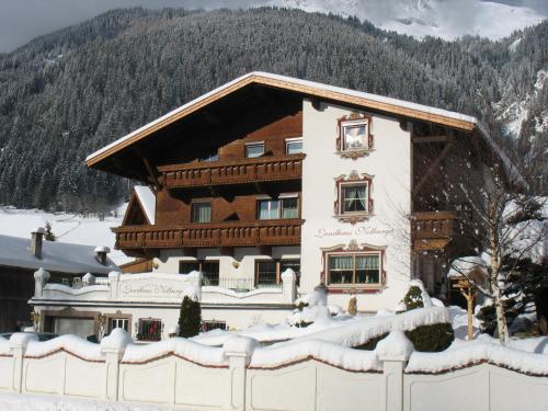 a building covered in snow in front of a mountain at Landhaus Notburga in Gries im Sellrain