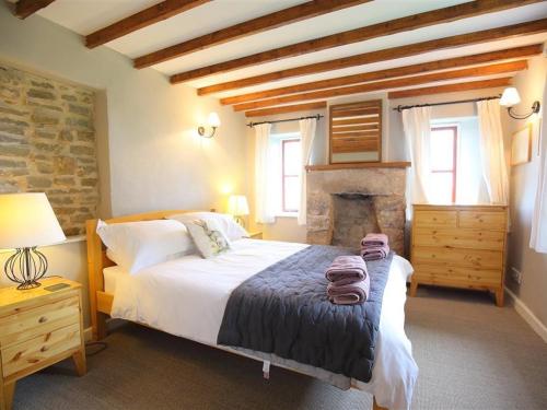 a bedroom with a large bed and a fireplace at The Cottage in Saint Briavels