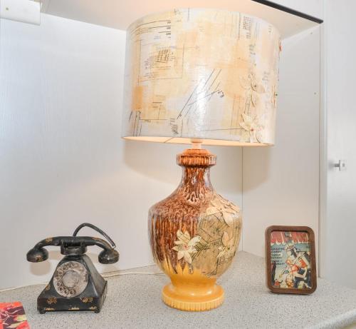 a lamp on a table next to a clock and a alarm clock at Land Of Lost Treasure in Maleny