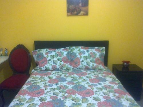 a bedroom with a bed with a pillow and a chair at Strenua - Las Quintanas in Trujillo