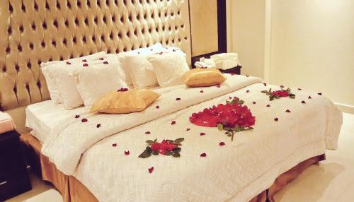 a bed with flowers on it in a bedroom at لؤلؤة الشرق للشقق المخدومة Luluat Al sharq For Serviced Apartment in Hafr Al Baten