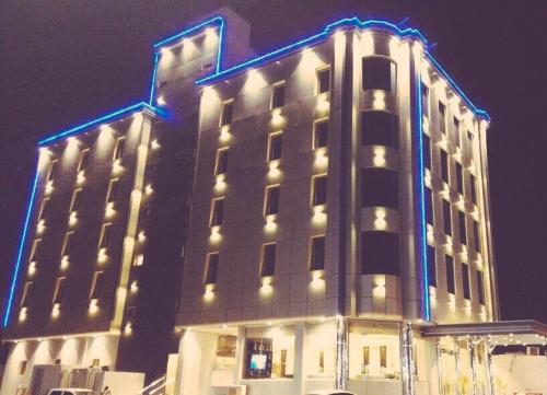 a large building with lights on it at night at لؤلؤة الشرق للشقق المخدومة Luluat Al sharq For Serviced Apartment in Hafr Al Baten