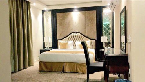 a bedroom with a large bed and a desk and a bed sidx sidx at لؤلؤة الشرق للشقق المخدومة Luluat Al sharq For Serviced Apartment in Hafr Al Baten