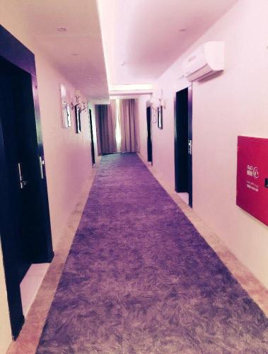 a long hallway with a purple carpet in a building at لؤلؤة الشرق للشقق المخدومة Luluat Al sharq For Serviced Apartment in Hafr Al Baten