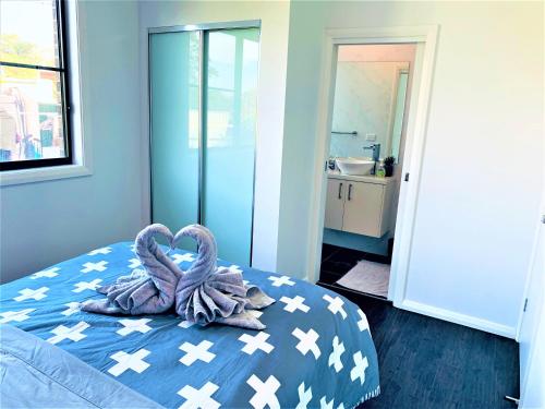 two swans are sitting on a bed in a bedroom at Revesby New Self Contained Granny Flat in Revesby