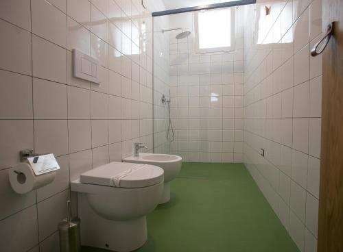 a white bathroom with a toilet and a sink at Senia_rooms_design in Santa Maria al Bagno