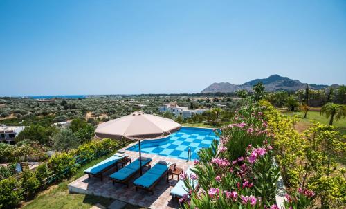 Villa con piscina y sombrilla en Kolymbia Village en Kolimbia