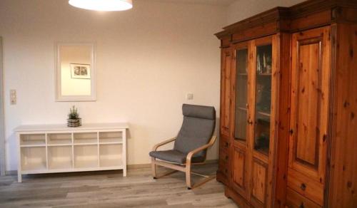 a living room with a chair and a cabinet at Ferienwohnung Lipizzaner in Neußen