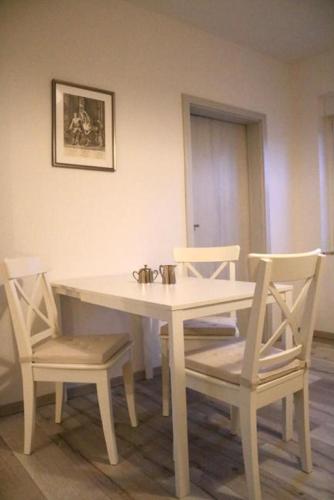 uma mesa branca com duas cadeiras, uma mesa branca e uma espreguiçadeira em Ferienwohnung Lipizzaner em Neußen