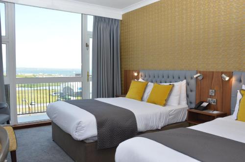 a hotel room with two beds and a balcony at Majestic Hotel in Tramore