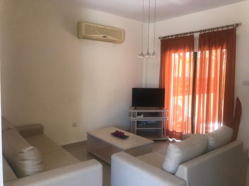 a living room with a couch and a tv at Kyklades Resort & Spa in Paralimni