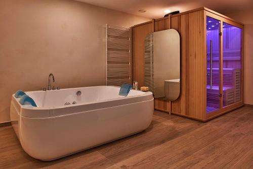 a large bathroom with a tub and a mirror at Villa Maria Vittoria in Nervesa della Battaglia