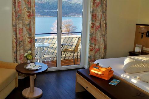 a hotel room with a bed and a balcony at Flairhotel am Wörthersee in Schiefling am See