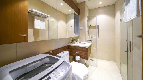 a bathroom with a toilet and a sink and a mirror at Tambuli Seaside Resort and Spa in Mactan