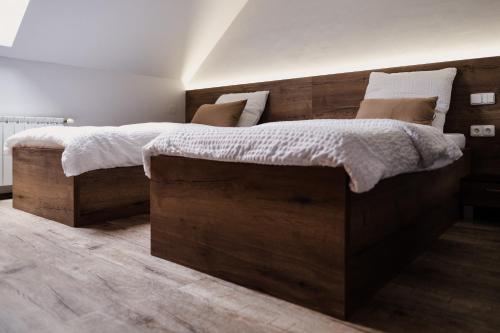 a bedroom with a large wooden bed with white sheets at Penzion Prestige Tennis Park in Frýdek-Místek