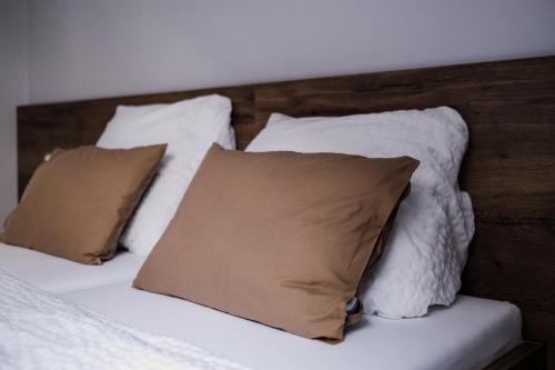 a bed with white pillows and a wooden headboard at Penzion Prestige Tennis Park in Frýdek-Místek