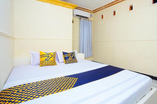 SPOT ON 2473 Buana Jaya Guest House tesisinde bir odada yatak veya yataklar