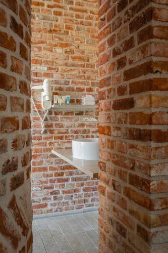 a bathroom with a brick wall and a sink at Hindsgavl Slot in Middelfart