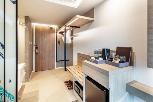 a kitchen with a counter and a door in a room at Hotel Amber Pattaya in Pattaya Central